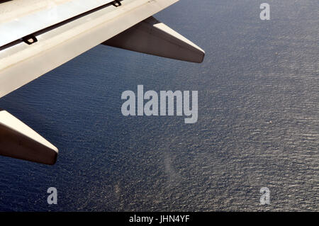 Teil von einem Flugzeugflügel mit dem Ozean unten. Stockfoto