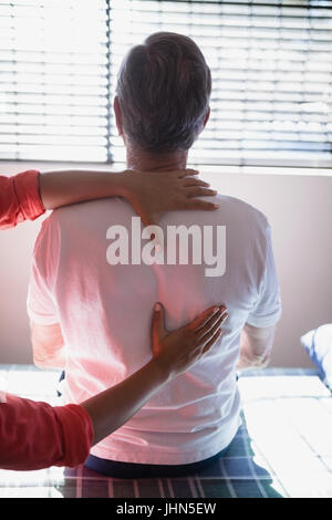 Rückansicht des senior männlichen Patienten empfangenden Rückenmassage von weiblichen Therapeuten im Krankenhaus Stockfoto