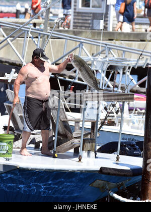 Ein Mann sich einen fangfrischen Fisch im Hafen von Provincetown, Massachusetts auf Cape Cod zu reinigen Stockfoto