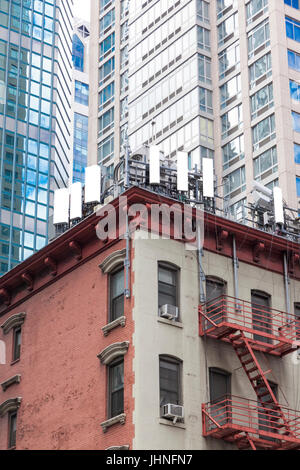 Handy-Antennen auf einem Flachbau Ecke Wohnhaus Dach in Midtown East, New York City, NY, Vereinigte Staaten Stockfoto