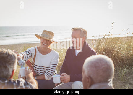 Ältere Ehepaare Kaffeetrinken am Sonnenstrand Stockfoto