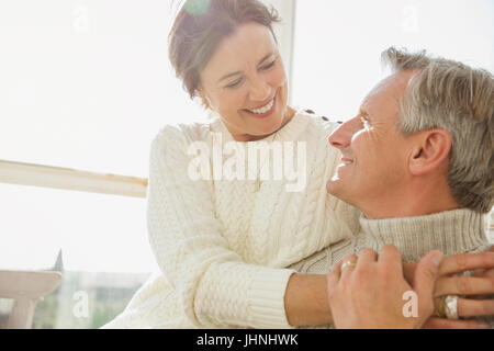 Liebevolle älteres paar umarmt auf sonnige Veranda Stockfoto