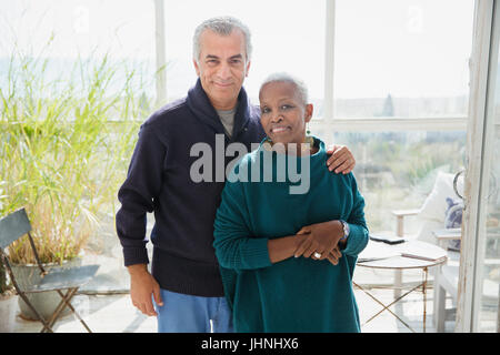 Porträt zärtlich älteres Paar am Strand Haus Sonnenterasse Stockfoto
