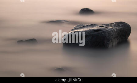 Stein im nebligen Wasser Stockfoto