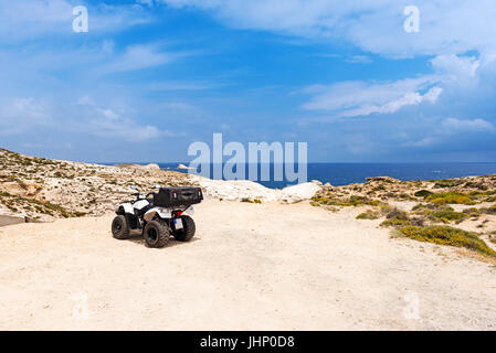 Quad geparkt auf der wunderschönen Küste von Milos-Insel nahe dem Strand Sarakiniko, Kykladen, Griechenland. Stockfoto