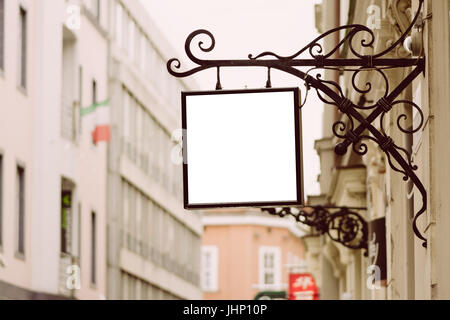 Leere Quadrat Schild, klassische Architektur Gebäude Hintergrund von Schmiedeeisen Halterung, in der Stadt hängen. Stockfoto