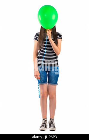 Teenager-Mädchen mit Ballon decken ihr Gesicht auf weißem Hintergrund. Stockfoto