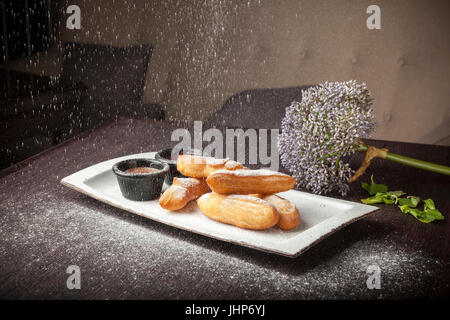 Donuts mit Schokoladensauce und Früchten auf Tisch Stockfoto