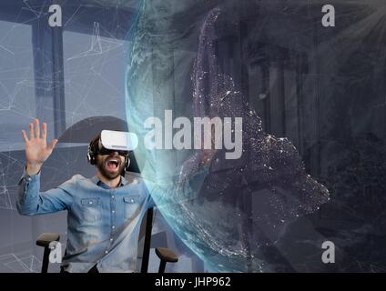 Digitale Zusammensetzung der überraschte Mann in VR Kopfhörer Blick auf eine 3D Planeten gegen Himmelshintergrund Stockfoto