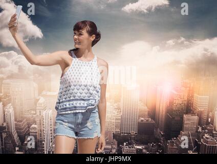 Digitalen Verbund aus tausendjährigen Mädchen in Sommerkleidung nehmen Selfie gegen Skyline mit Wolken Stockfoto