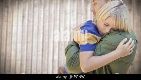 Digitalen Verbund von Vater und Sohn umarmt gegen verschwommen Holzplatte Stockfoto