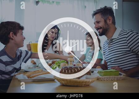 Digitalen Verbund aus Uhrsymbol gegen Familie Abendessen Foto Stockfoto