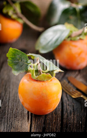 Kaki Früchte auf Holztisch Stockfoto