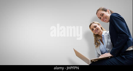 Porträt von Geschäftsfrauen posiert mit Laptop gegen graue vignette Stockfoto