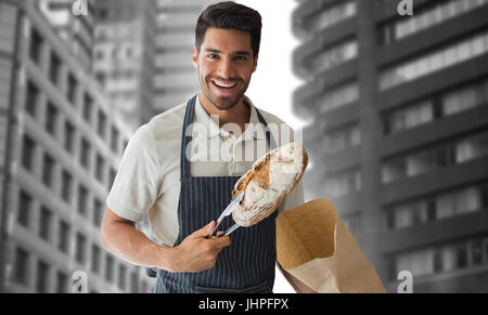 Baker Verpackung Laib Brot gegen Blick auf die Gebäude der Stadt Stockfoto
