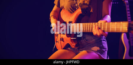 Mittleren Bereich der Frau spielt Gitarre bei Konzert in Nachtclub Stockfoto