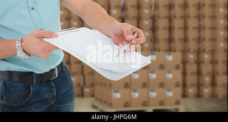 Lieferung Mann mit Zwischenablage Fragen zur Unterschrift gegen braune Kartons auf weißem Hintergrund Stockfoto