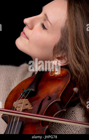 leidenschaftlicher Geiger spielen ihr klassische Musik-Instrument auf einem schwarzen Hintergrund und genießen. Stockfoto