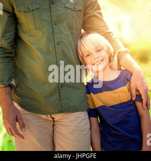 Porträt eines Vaters mit seinem Sohn gegen Fokus auf Haus in einem Garten Stockfoto