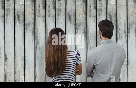 Rückansicht von Mann und Frau mit verschränkten Armen gegen Holz Hintergrund Stockfoto