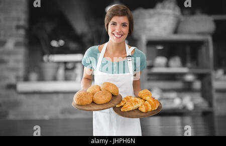 Kellnerin mit Croissant auf einem Tablett gegen leere Zähler im Coffee shop Stockfoto