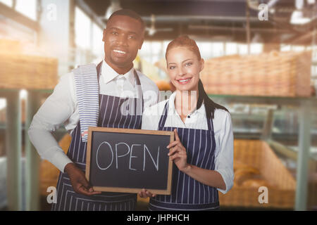 Porträt von lächelnden Personal holding schreiben Schiefer mit Text gegen lächelnden Kellner Schürze Auswahl Brot Stockfoto