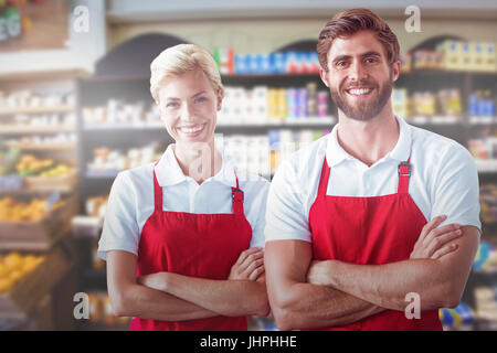 Porträt von Kollegen mit verschränkten gegen Produkte in den Regalen Stockfoto