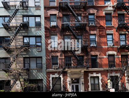 New York, NY USA--12. Juli 2017--kontrastierenden Fassaden der beiden Wohnung sehenswert mit externen Feuerleitern in New Yorks Greenwich Village. Edito Stockfoto