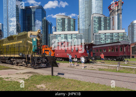 Toronto, Kanada - 24. Juni 2017: Sammlung alter Züge im Toronto Railway Museum im Roundhouse Park in Toronto mit Skyline im Hintergrund. Stockfoto
