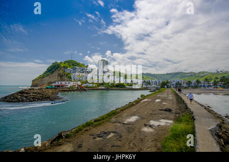 Nahaufnahme von einem felsigen Strand und Gebäude hinter in einen schönen Tag mit Sonnenschein am blauen Himmel in gleichen, Ecuador. Stockfoto