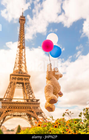 Niedlichen Teddybären fliegen mit Trikolore Ballons bis zu den Vintage hellen Himmel vor dem Eiffelturm, Paris, Frankreich (Kopie) Stockfoto