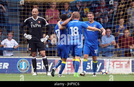 Watford Torhüter Heurelho Gomes (links) sieht niedergeschlagen, wie AFC Wimbledon Cody McDonald (rechts) mit seinen Teamkollegen, feiert nachdem er seine und ihre Seite zweite Tor des Spiels während der Vorsaison Spiele im Stadium Cherry Red Records, London erzielt. Stockfoto