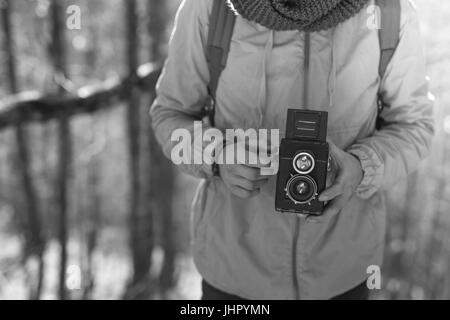 Retro-stilisierte Foto des jungen Mannes Fotografen mit Vintage-Kamera Stockfoto