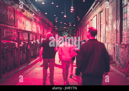 Menschen gehen auf der Straße in der Nacht in Ausgeh-Zentrum - verschwommen Stockfoto