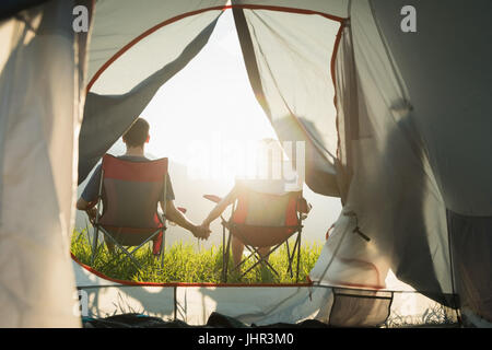 Rückansicht des Paares sitzend mit hand auf Campingplatz Stockfoto