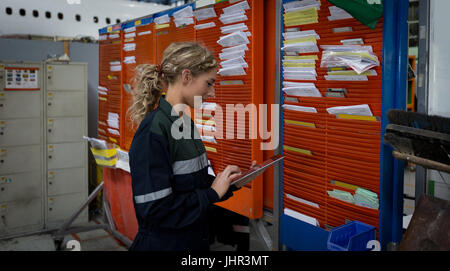 Weibliche Flugzeugingenieur Wartung mit digital-Tablette bei Fluggesellschaften Wartungsbetrieb Stockfoto