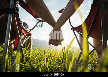 Mittelteil des Paares sitzend mit hand auf Campingplatz Stockfoto