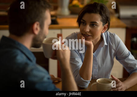 Paar im Gespräch bei Kaffee am Tisch in der Küche Stockfoto