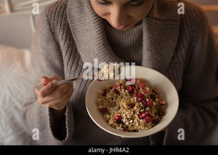 Nahaufnahme von Frau frühstücken beim Sitzen auf dem Bett zu Hause Stockfoto