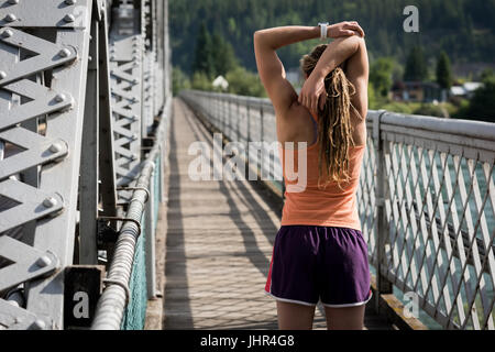 Rückansicht des stretching mit auf Steg erhobenen Armen Frau Stockfoto