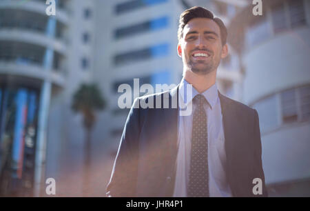 Porträt von lächelnden Geschäftsmann stand in der Nähe Bürogebäude Stockfoto