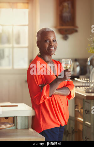 Porträt, Lächeln senior Frau Wein trinken in Küche Stockfoto