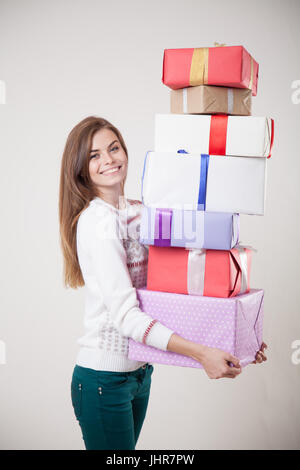 Mädchen hält viele Geschenke lächelt 1 2 Stockfoto