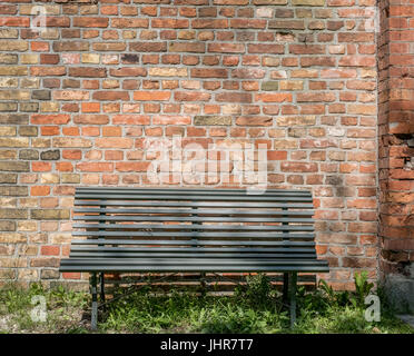 leere Holzbank mit Vintage Ziegel Wand Hintergrund - im freien Stockfoto