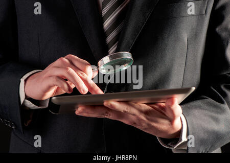 Geschäftsmann mit Lupe und digitale Tablet-Konzept für Internet-Suche Stockfoto