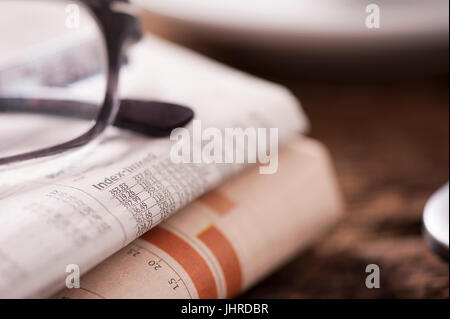 Brille liegen auf einem Stapel Zeitungen Stockfoto