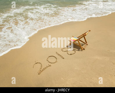Liegestuhl mit 2018 in Sand schreiben am tropischen Strand geschrieben. Stockfoto