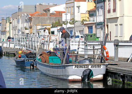 Ein Fischer flickt seine Netze auf einem Kanal in Zentralportugal Canal Aveiro Stockfoto