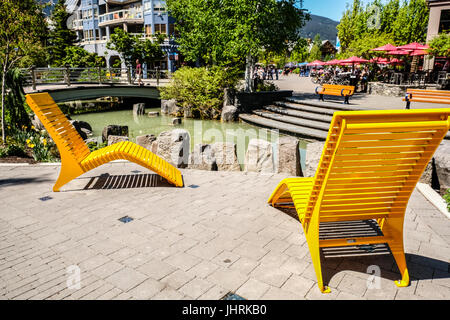 Zwei helle gelbe Liegestühlen in Whistler ski Resort im Sommer Stockfoto
