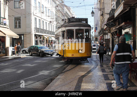 Ein Straßenbahn-Wagen Menschenmassen den Bürgersteig beim Drehen auf der Rua da Prata in der Baixa einkaufen Bezirk Lissabon Portugal Stockfoto